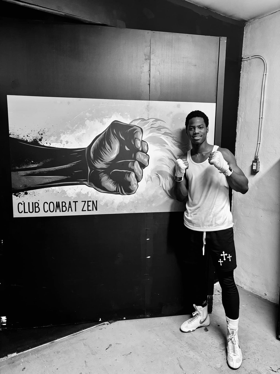 Un membre de Club Combat Zen devant la murale du gym